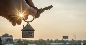 hand holding key to house