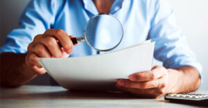 Man looking through magnifying glass