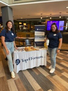Topel Forman accounting firm team members hosting a campus recruitment table with giveaways and internship information.